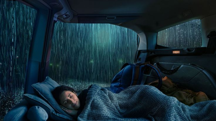 Image of someone sleeping peacefully in a camping van while raining.